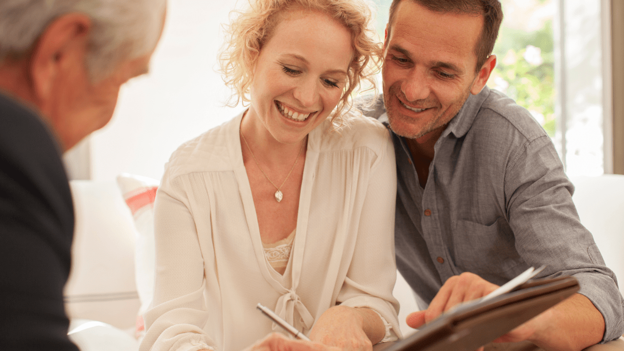 A middle-aged couple reviewing retirement plans with a financial advisor at Brookstone Financial in Jeffersonville, IN.
