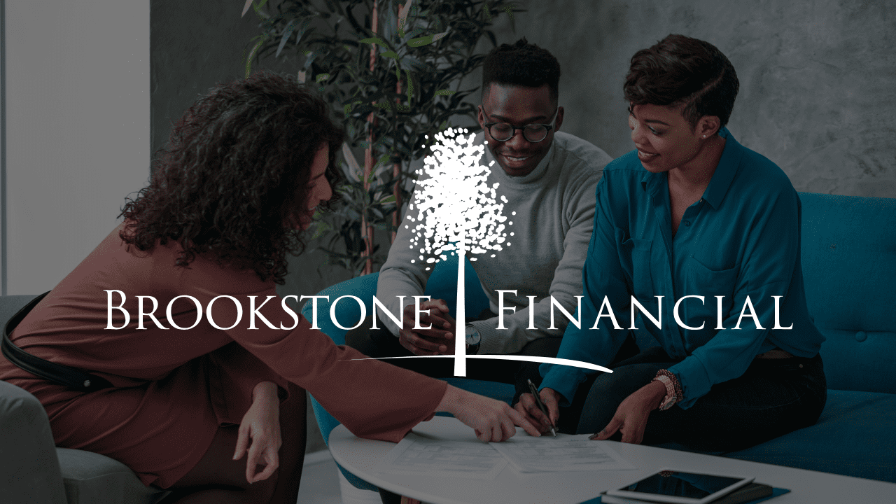 Professional financial advisor in Jeffersonville, Indiana, guiding a couple through retirement planning using a tablet.